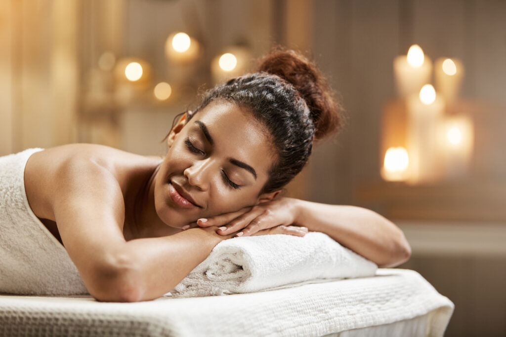 Beautiful african girl resting relaxing in spa resort with closed eyes. Spa